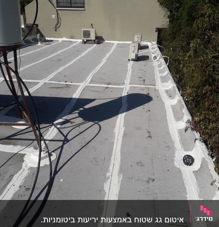 איטום גג עם חומר לבן לאורך התפרים